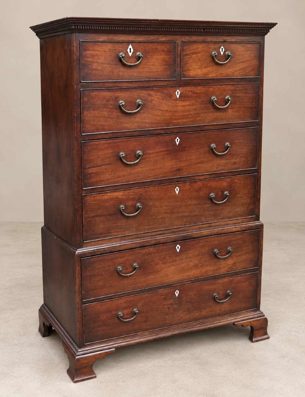 A tall Georgian mahogany chest on chest featuring brass swan-neck handles, diamond keyhole escutcheons, and ogee bracket feet. View IV