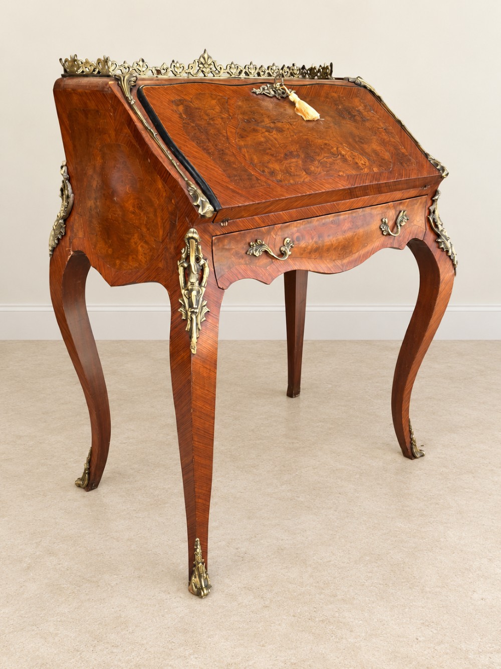 A 19th-century French Louis XV style walnut slant-front writing bureau featuring marquetry veneer, ornate gilt-bronze mounts, a brass pierced gallery, and long cabriole legs. View II