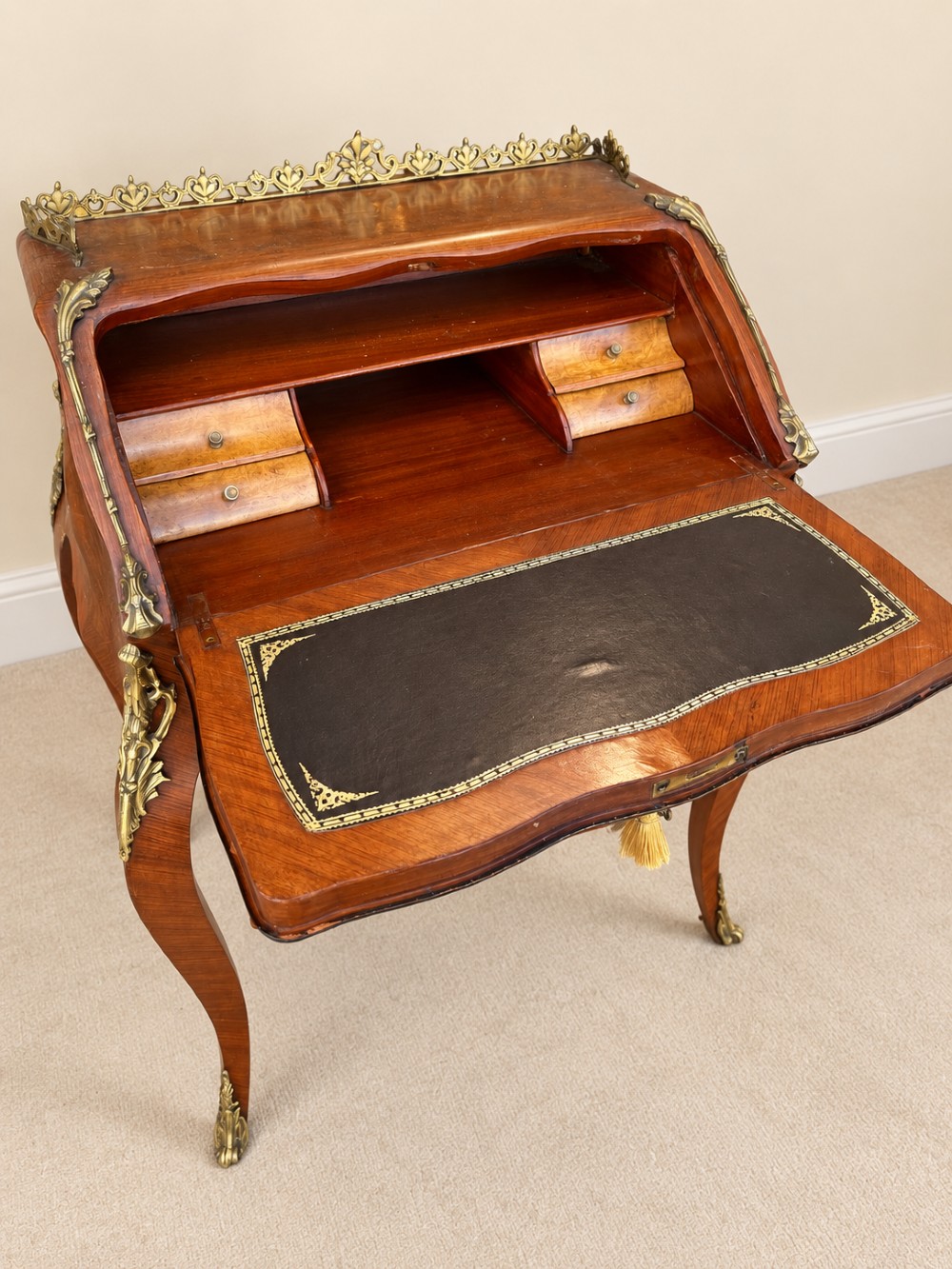 A 19th-century French Louis XV style walnut slant-front writing bureau featuring marquetry veneer, ornate gilt-bronze mounts, a brass pierced gallery, and long cabriole legs. View IV