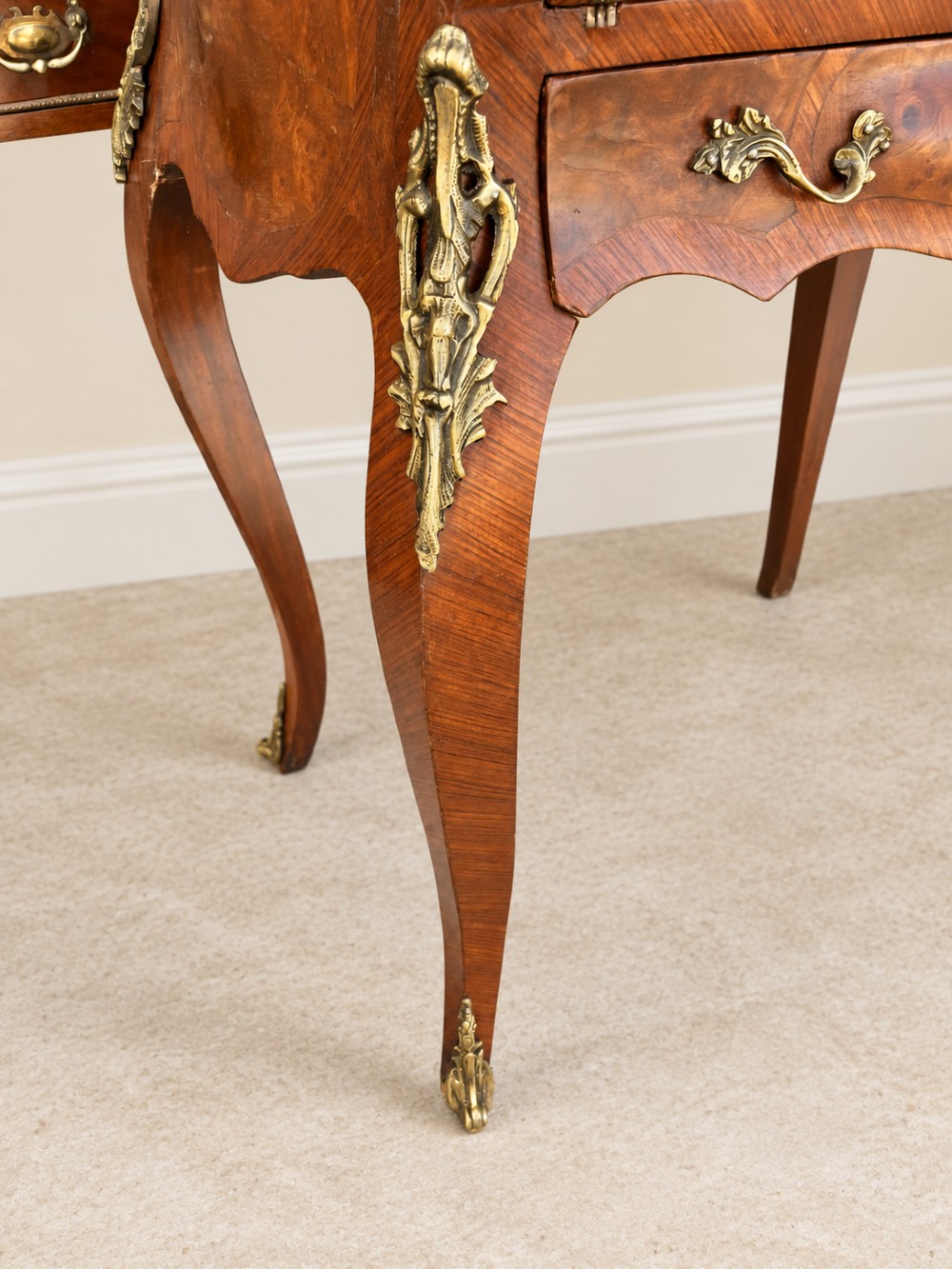 A 19th-century French Louis XV style walnut slant-front writing bureau featuring marquetry veneer, ornate gilt-bronze mounts, a brass pierced gallery, and long cabriole legs. View VI
