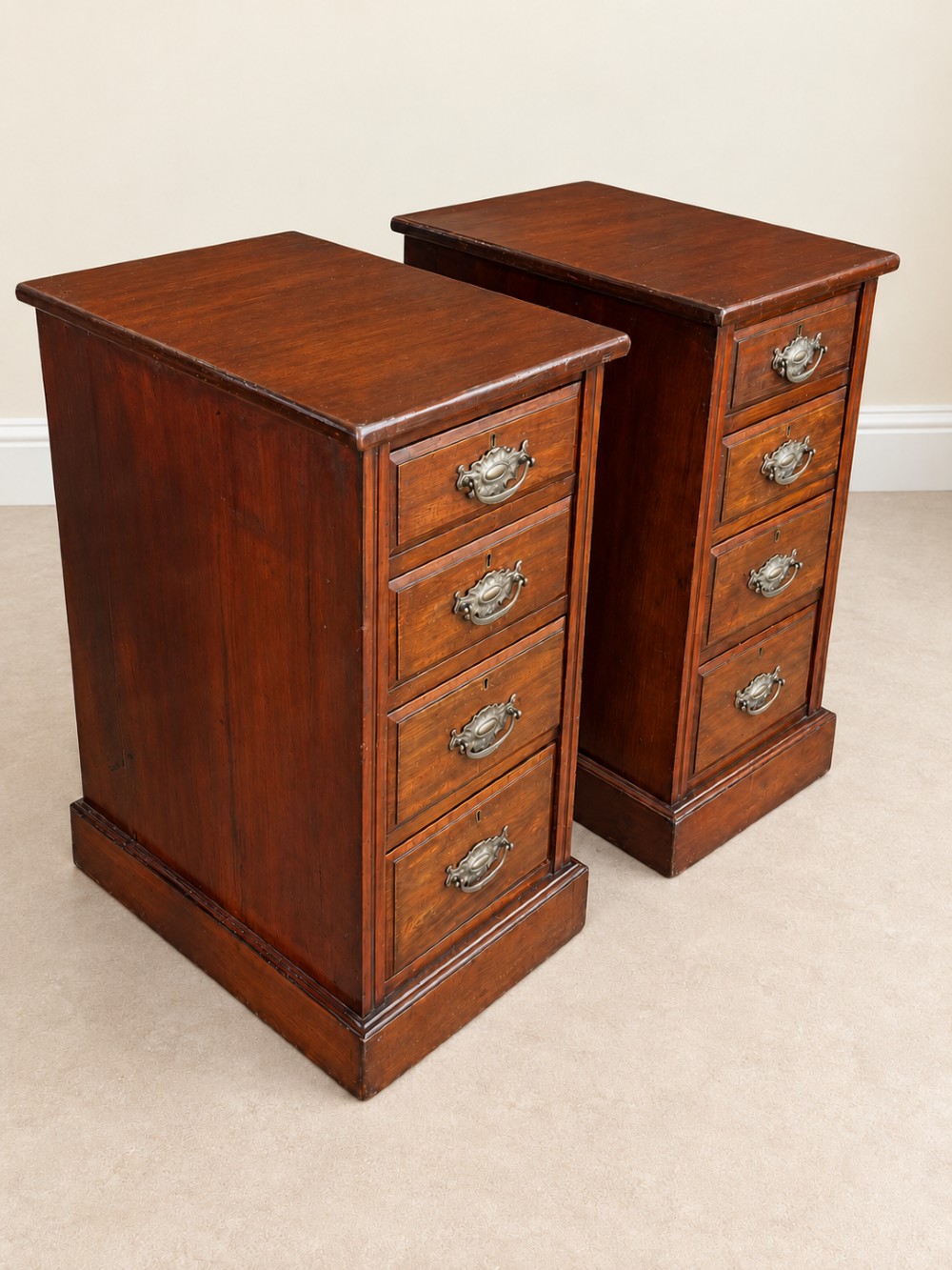 A pair of late Victorian mahogany bedside chests, each featuring four drawers with metal swing handles and a solid plinth base. View II