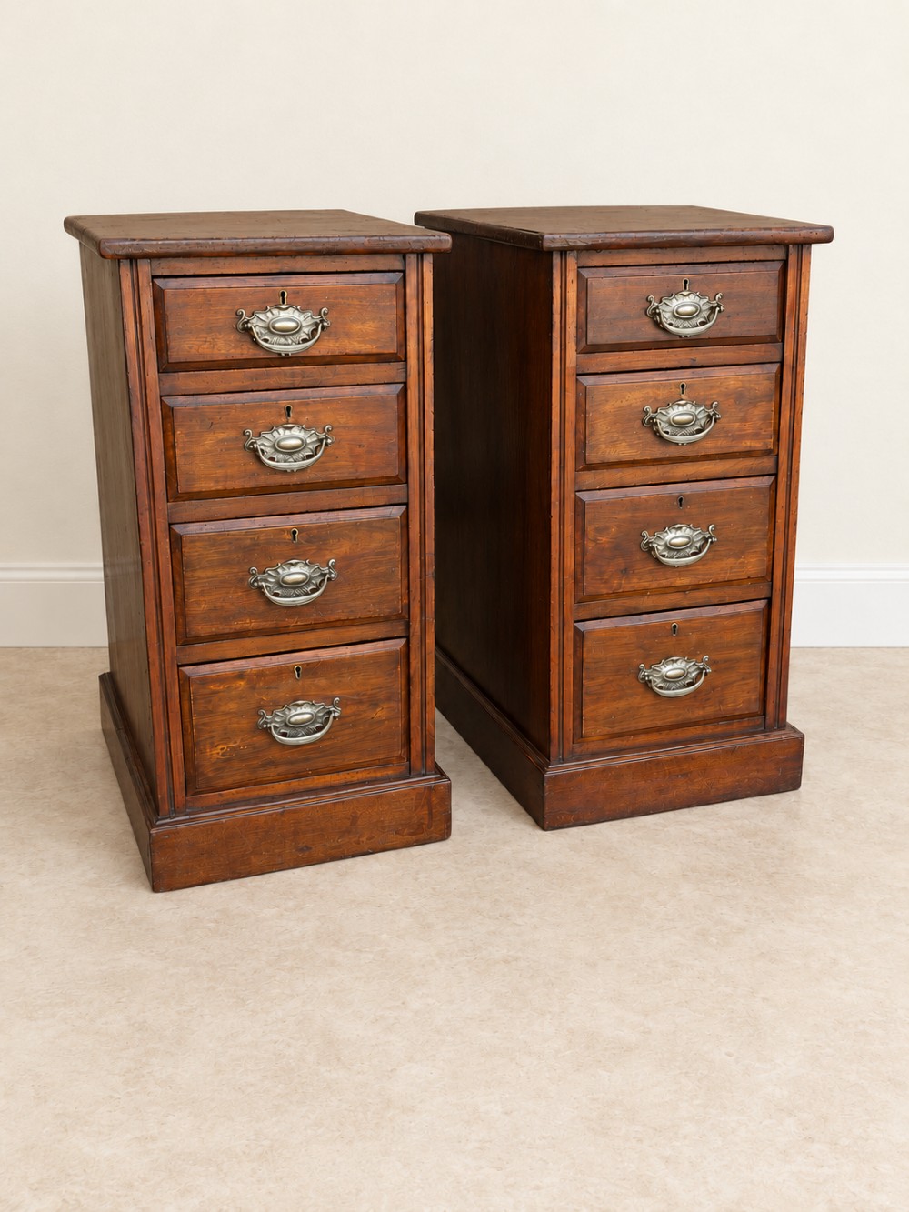 A pair of late Victorian mahogany bedside chests, each featuring four drawers with metal swing handles and a solid plinth base. View III