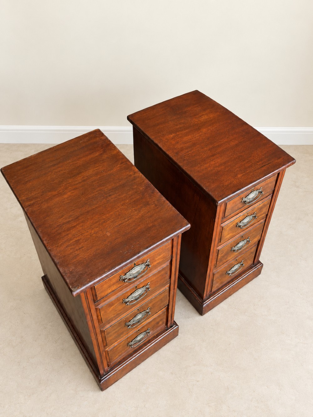 A pair of late Victorian mahogany bedside chests, each featuring four drawers with metal swing handles and a solid plinth base. View IV