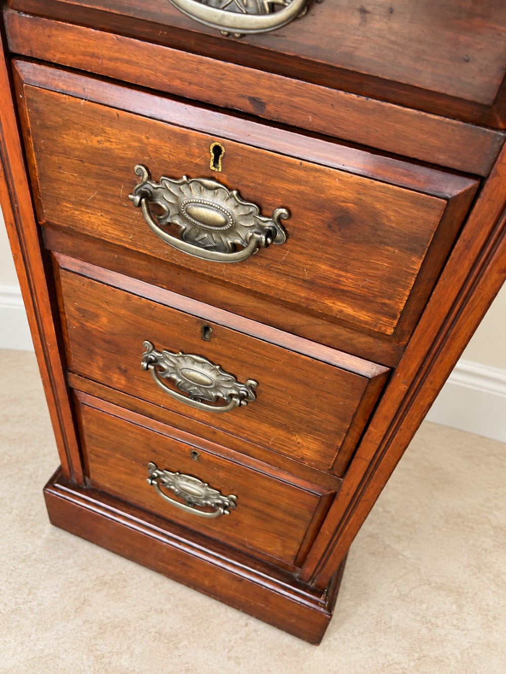 A pair of late Victorian mahogany bedside chests, each featuring four drawers with metal swing handles and a solid plinth base. View VI