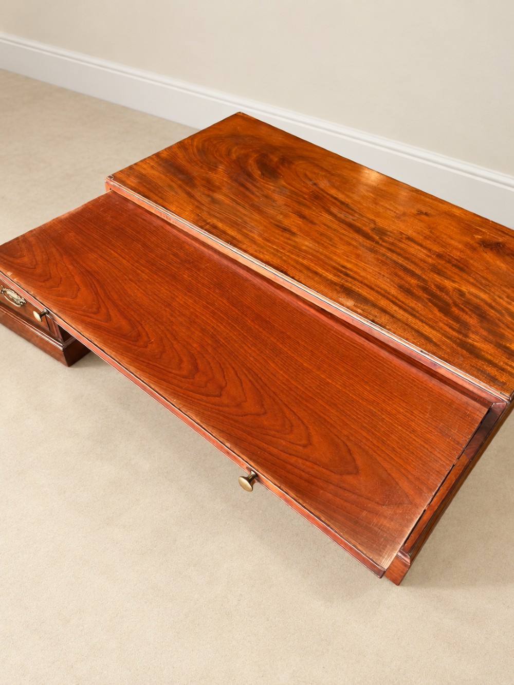 A Georgian mahogany bachelors chest featuring a brushing slide, two short over two long drawers, brass swan-neck handles, and bracket feet. View VI