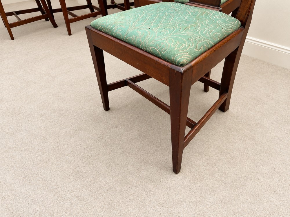 A set of six Georgian mahogany dining chairs featuring openwork pierced back splats, serpentine top rails, square legs with H-stretchers, and green patterned upholstered seats. View III