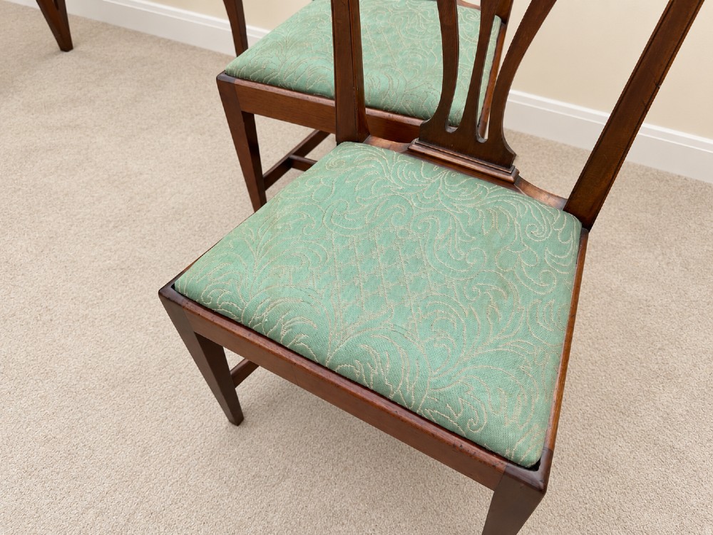 A set of six Georgian mahogany dining chairs featuring openwork pierced back splats, serpentine top rails, square legs with H-stretchers, and green patterned upholstered seats. View IV