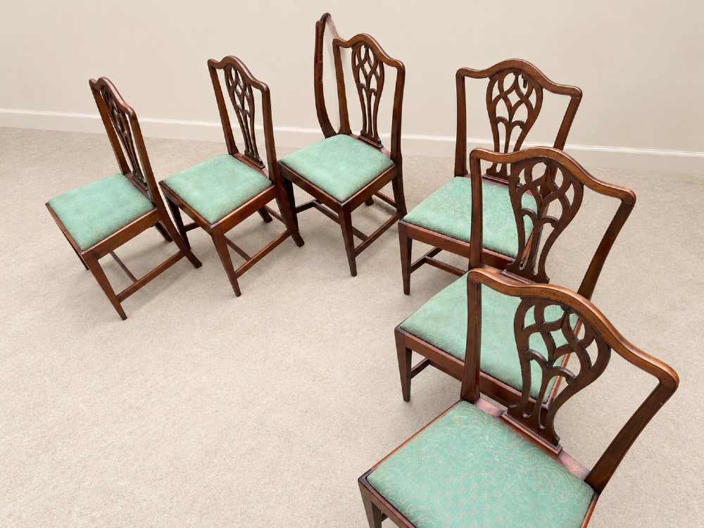 A set of six Georgian mahogany dining chairs featuring openwork pierced back splats, serpentine top rails, square legs with H-stretchers, and green patterned upholstered seats. View XI