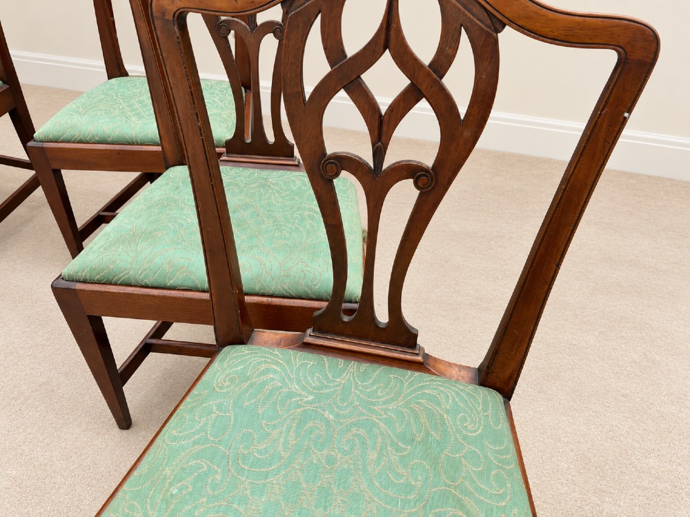 A set of six Georgian mahogany dining chairs featuring openwork pierced back splats, serpentine top rails, square legs with H-stretchers, and green patterned upholstered seats. View XII