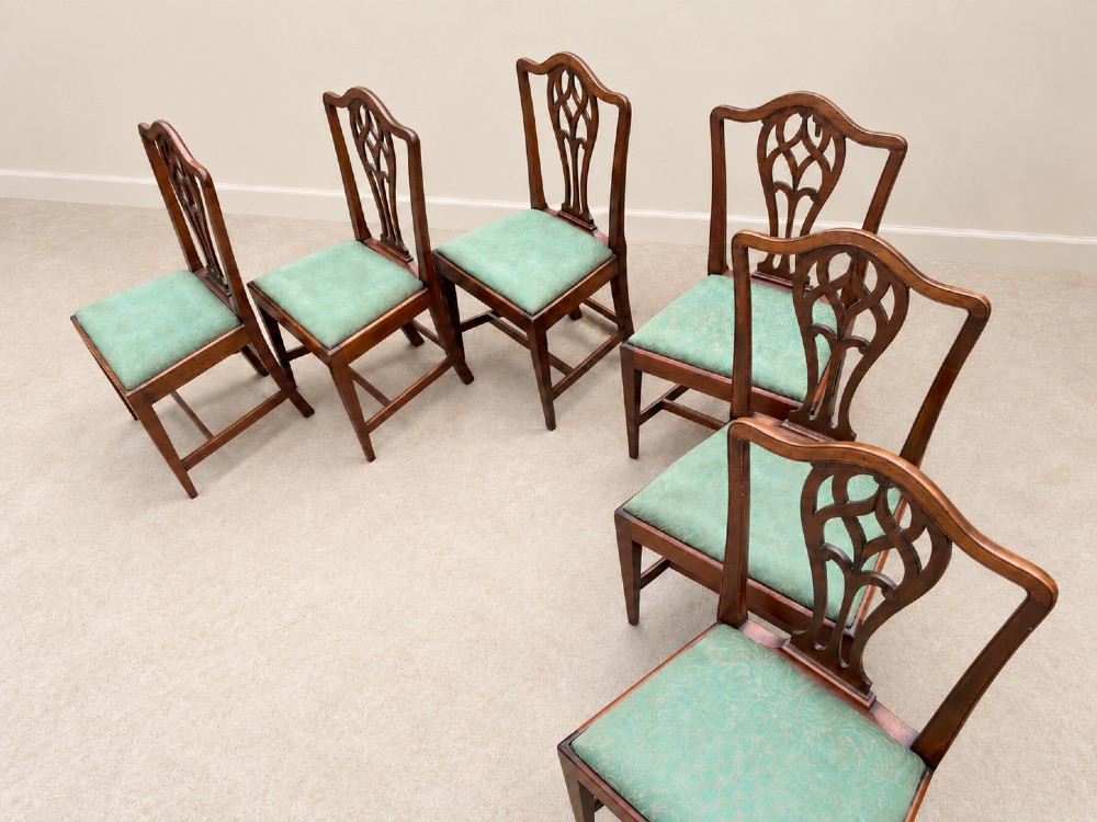 A set of six Georgian mahogany dining chairs featuring openwork pierced back splats, serpentine top rails, square legs with H-stretchers, and green patterned upholstered seats. View XIII