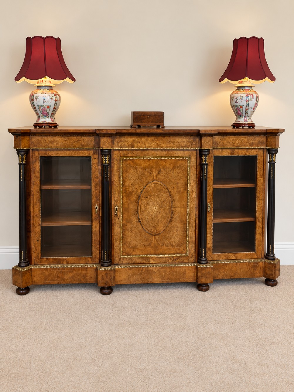 A 19th-century burr walnut credenza with a central marquetry-inlaid door flanked by two glass-front display cabinets and ebonised columns with gilt metal mounts. View II