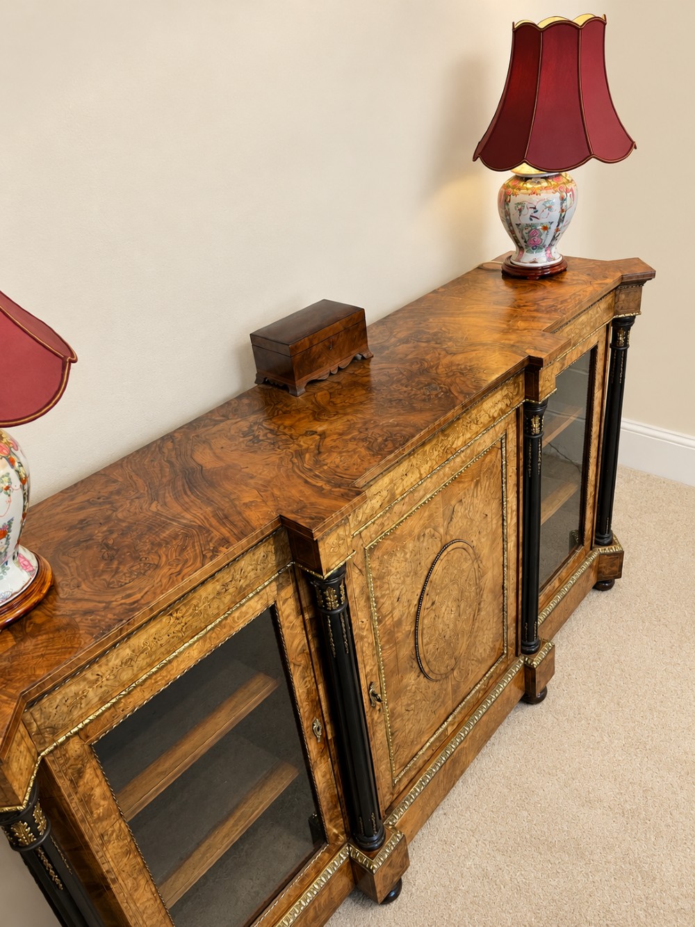 A 19th-century burr walnut credenza with a central marquetry-inlaid door flanked by two glass-front display cabinets and ebonised columns with gilt metal mounts. View V