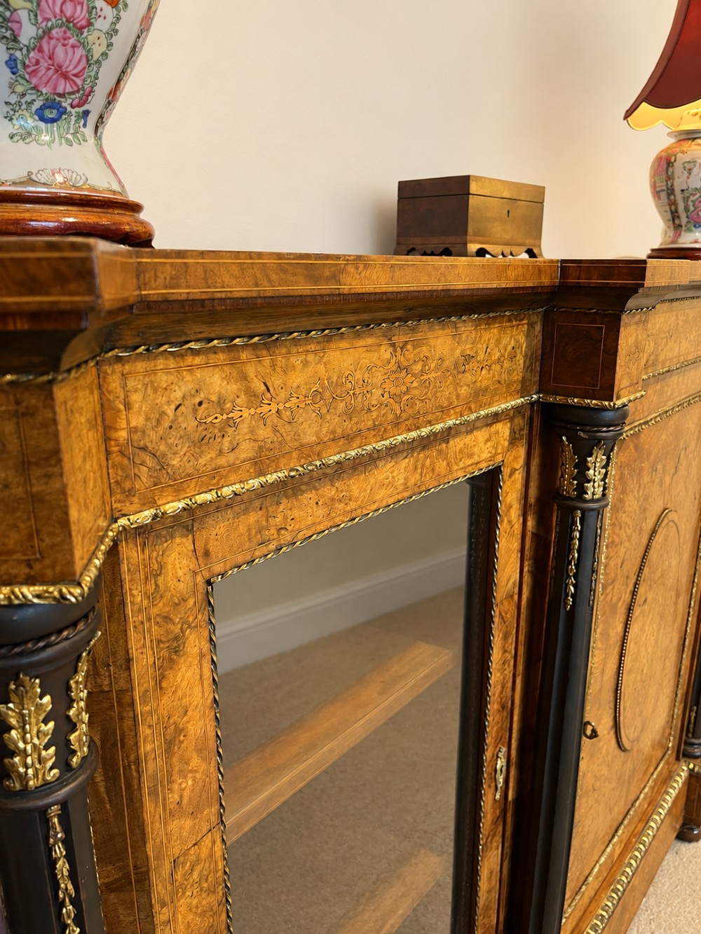 A 19th-century burr walnut credenza with a central marquetry-inlaid door flanked by two glass-front display cabinets and ebonised columns with gilt metal mounts. View VII