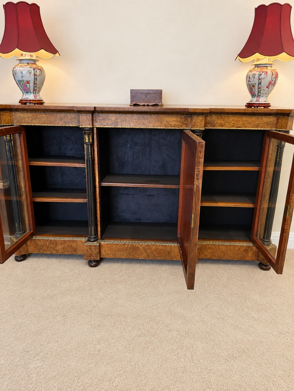 A 19th-century burr walnut credenza with a central marquetry-inlaid door flanked by two glass-front display cabinets and ebonised columns with gilt metal mounts. View XI