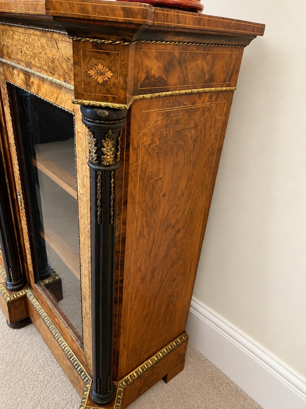 A 19th-century burr walnut credenza with a central marquetry-inlaid door flanked by two glass-front display cabinets and ebonised columns with gilt metal mounts. View XII