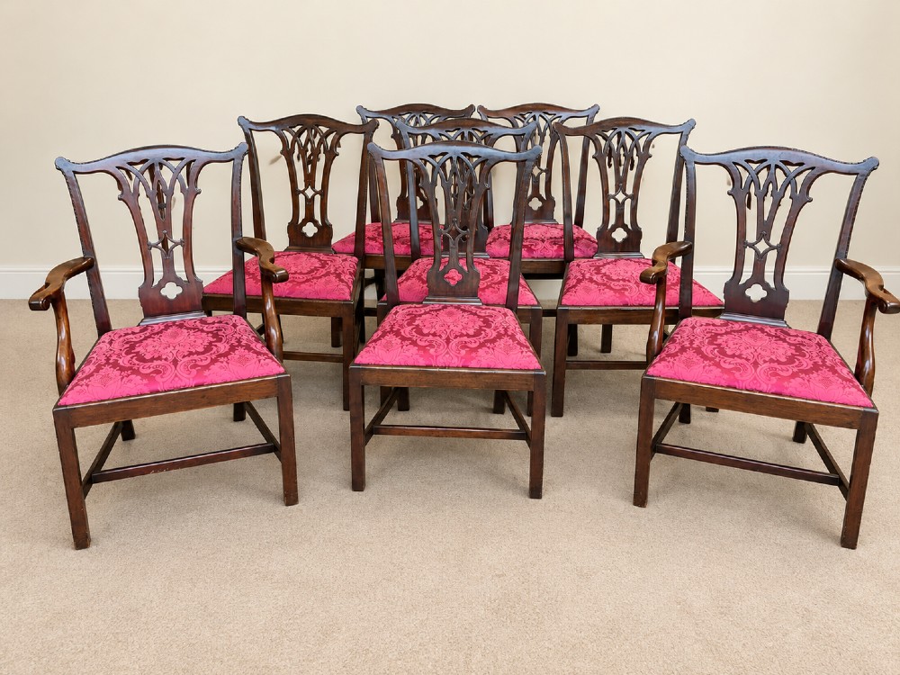 A set of eight antique Chippendale style mahogany dining chairs featuring carved pierced splats and magenta damask upholstered seats. View II