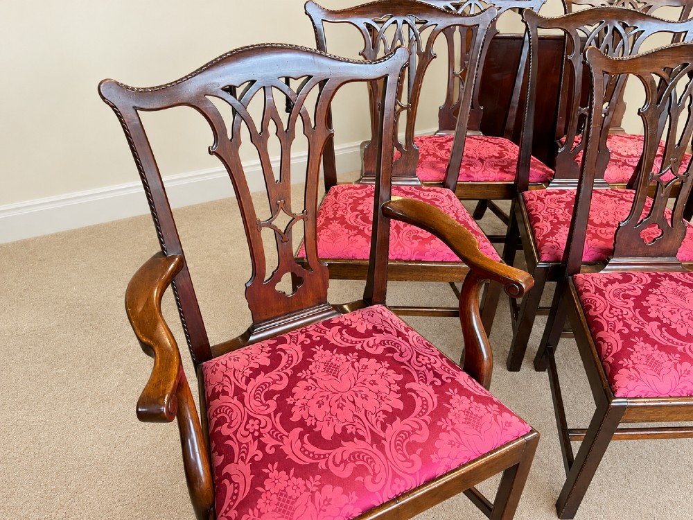 A set of eight antique Chippendale style mahogany dining chairs featuring carved pierced splats and magenta damask upholstered seats. View III