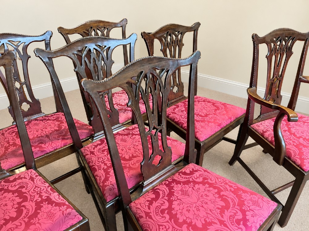 A set of eight antique Chippendale style mahogany dining chairs featuring carved pierced splats and magenta damask upholstered seats. View V