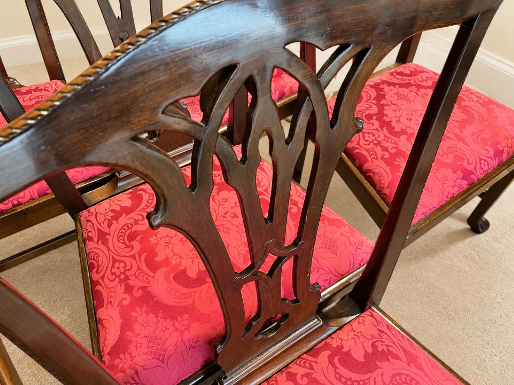 A set of eight antique Chippendale style mahogany dining chairs featuring carved pierced splats and magenta damask upholstered seats. View VI