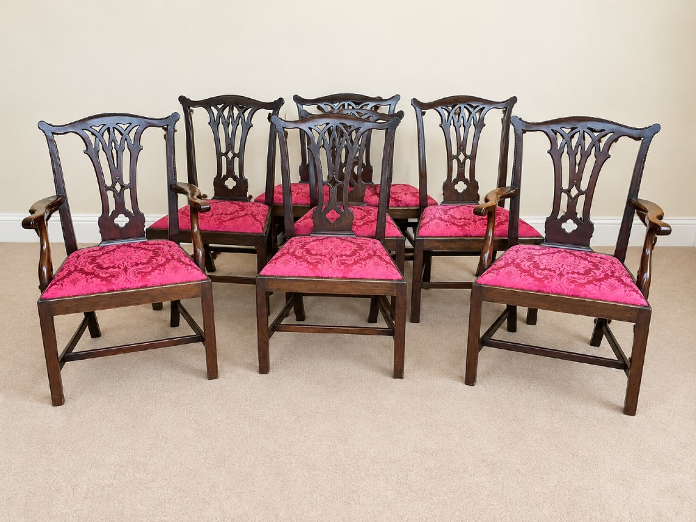 A set of eight antique Chippendale style mahogany dining chairs featuring carved pierced splats and magenta damask upholstered seats. View VII