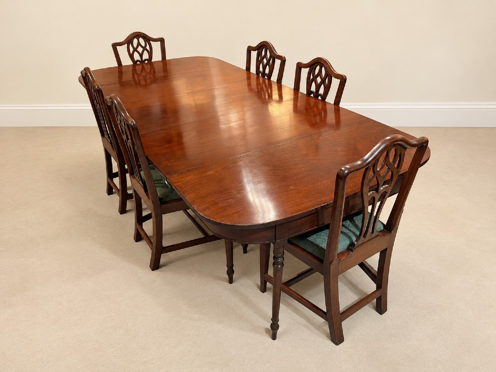 An extendable Regency mahogany dining table featuring rounded D-shaped ends, extra leaf insertions, and turned legs with brass castors. View VIII