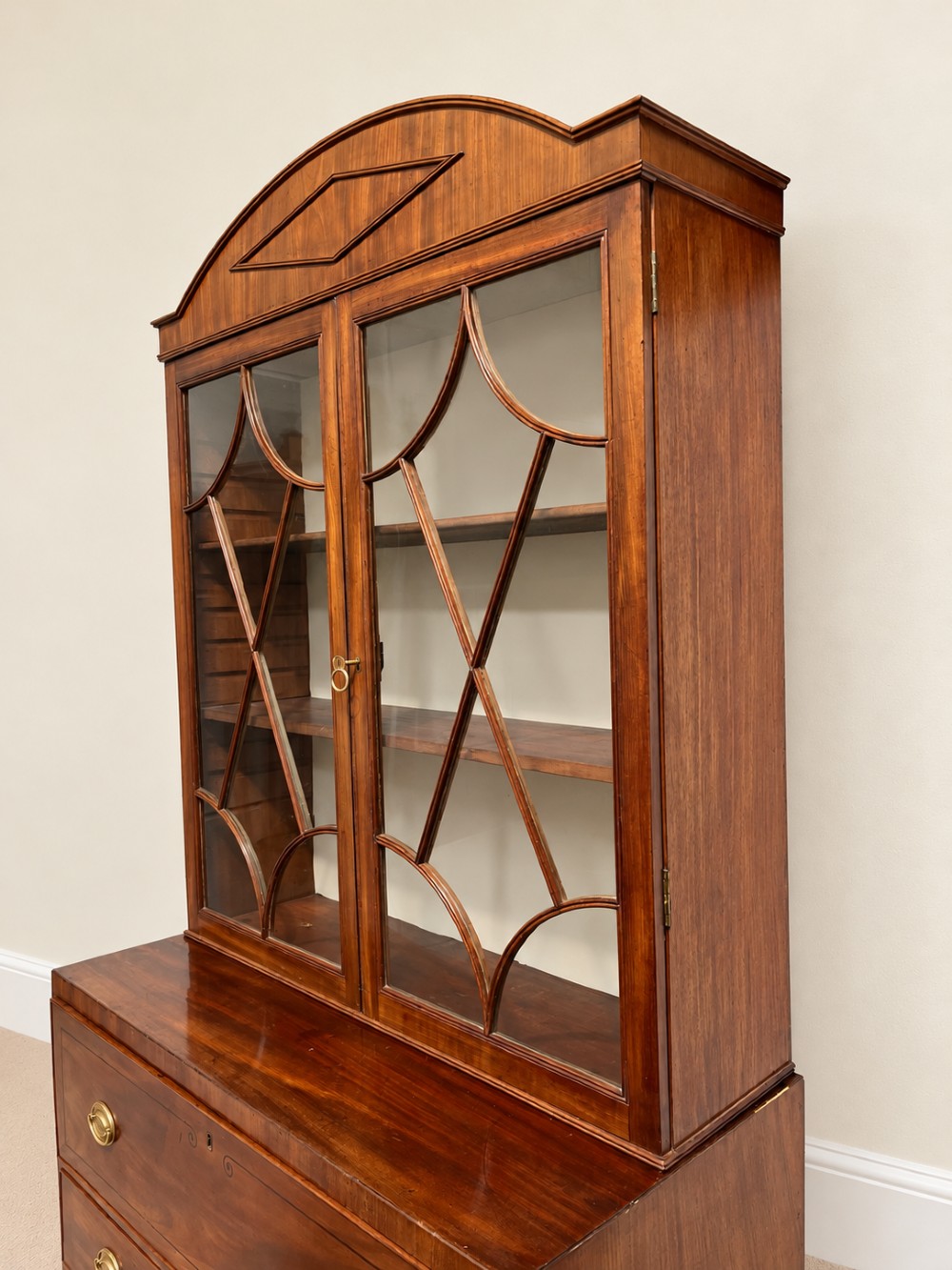A 19th-century mahogany secretaire bookcase featuring an arched pediment, astragal glazed upper doors, and a four-drawer base with circular brass handles. View III