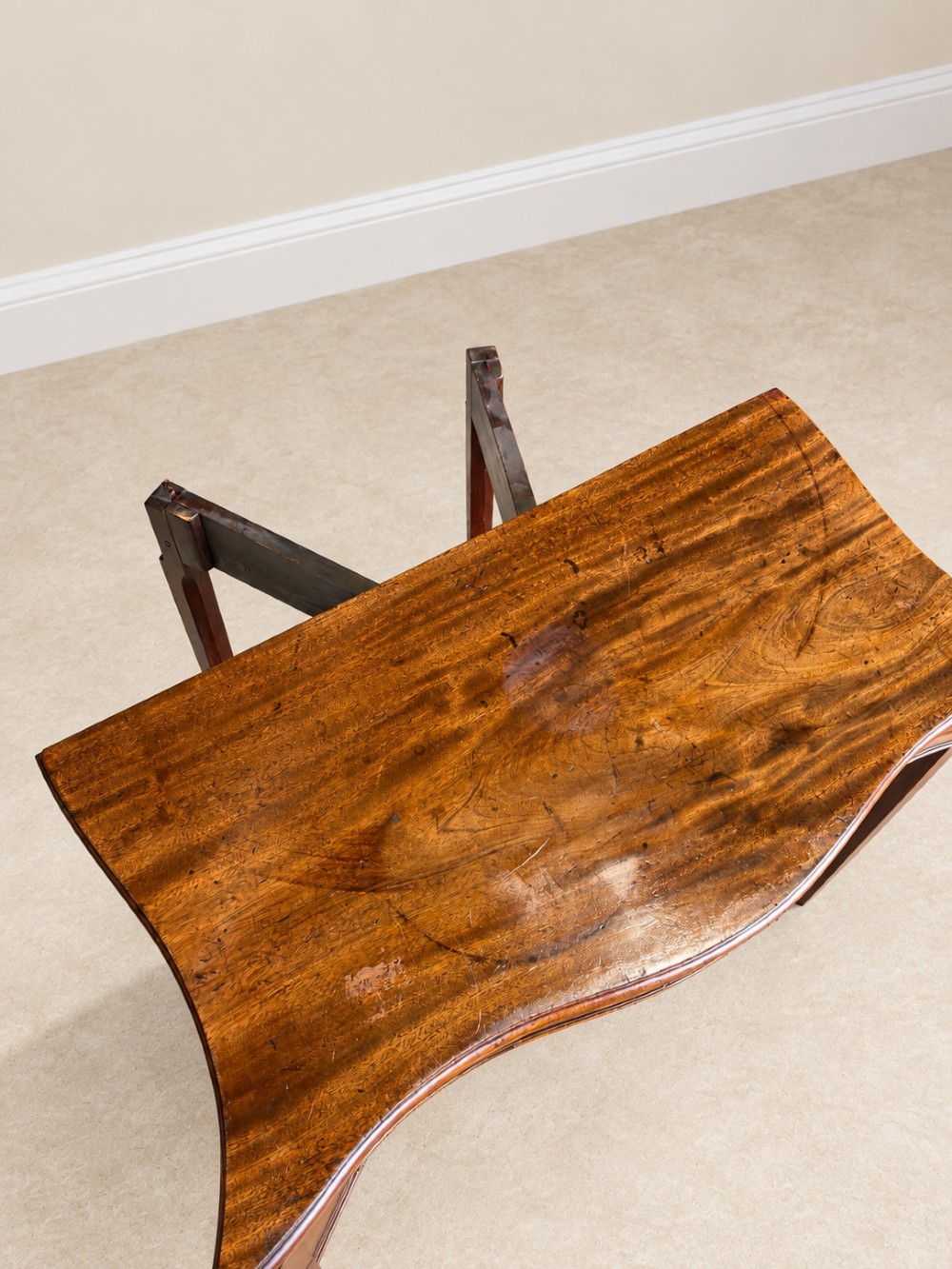 An antique Georgian dark mahogany fold-over table featuring a serpentine-curved front apron and four straight legs. View VIII