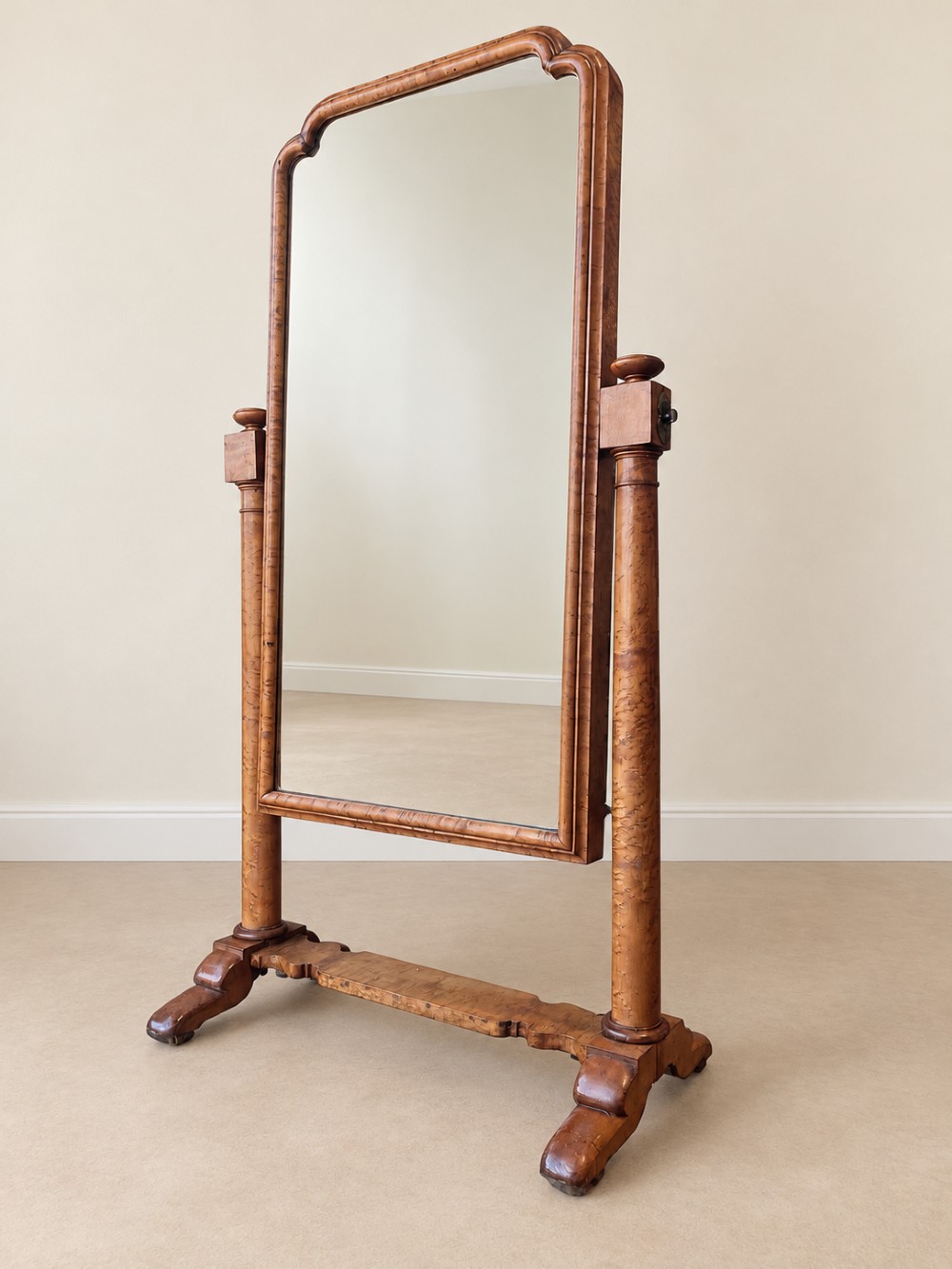 A 19th-century full-length satin birch cheval mirror featuring an arched top frame supported by turned upright pillars on splayed legs.
