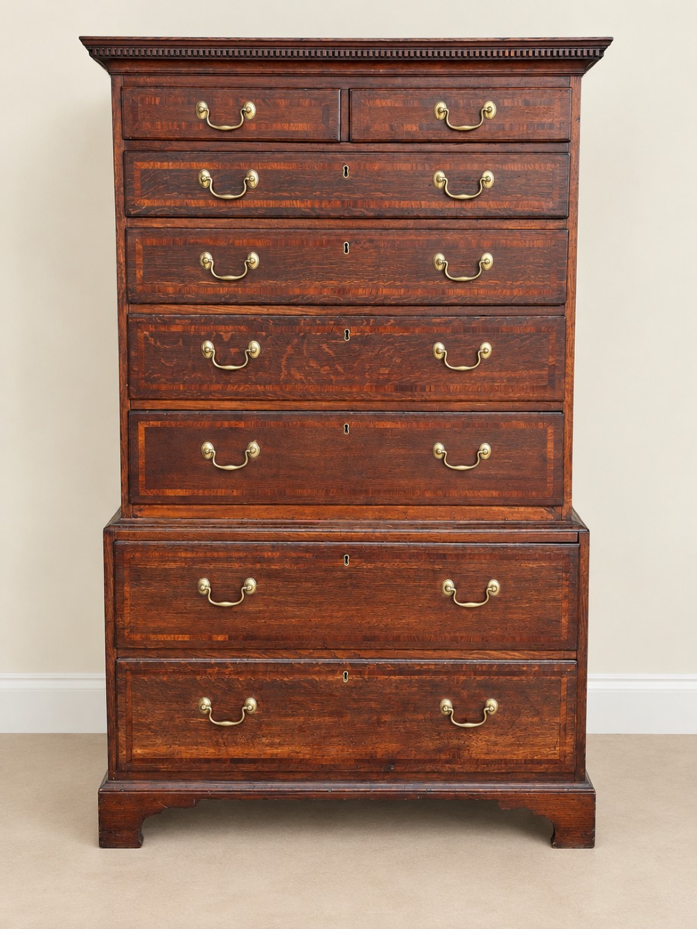 An antique Georgian oak chest on chest featuring two small top drawers over five full-width graduated drawers with brass swan-neck handles and bracket feet. View II