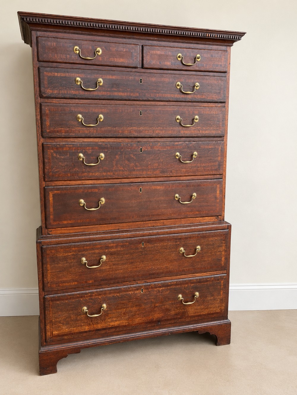 An antique Georgian oak chest on chest featuring two small top drawers over five full-width graduated drawers with brass swan-neck handles and bracket feet. View III