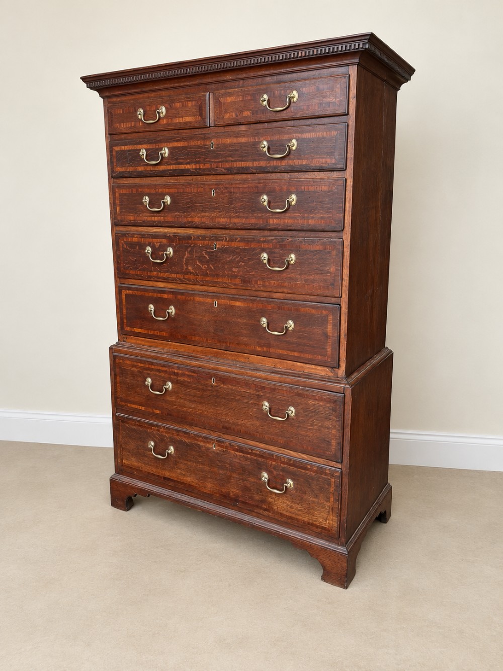 An antique Georgian oak chest on chest featuring two small top drawers over five full-width graduated drawers with brass swan-neck handles and bracket feet. View IV