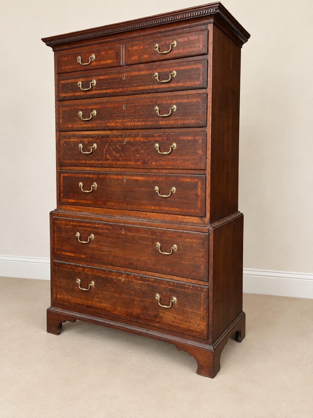 An antique Georgian oak chest on chest featuring two small top drawers over five full-width graduated drawers with brass swan-neck handles and bracket feet. View VI