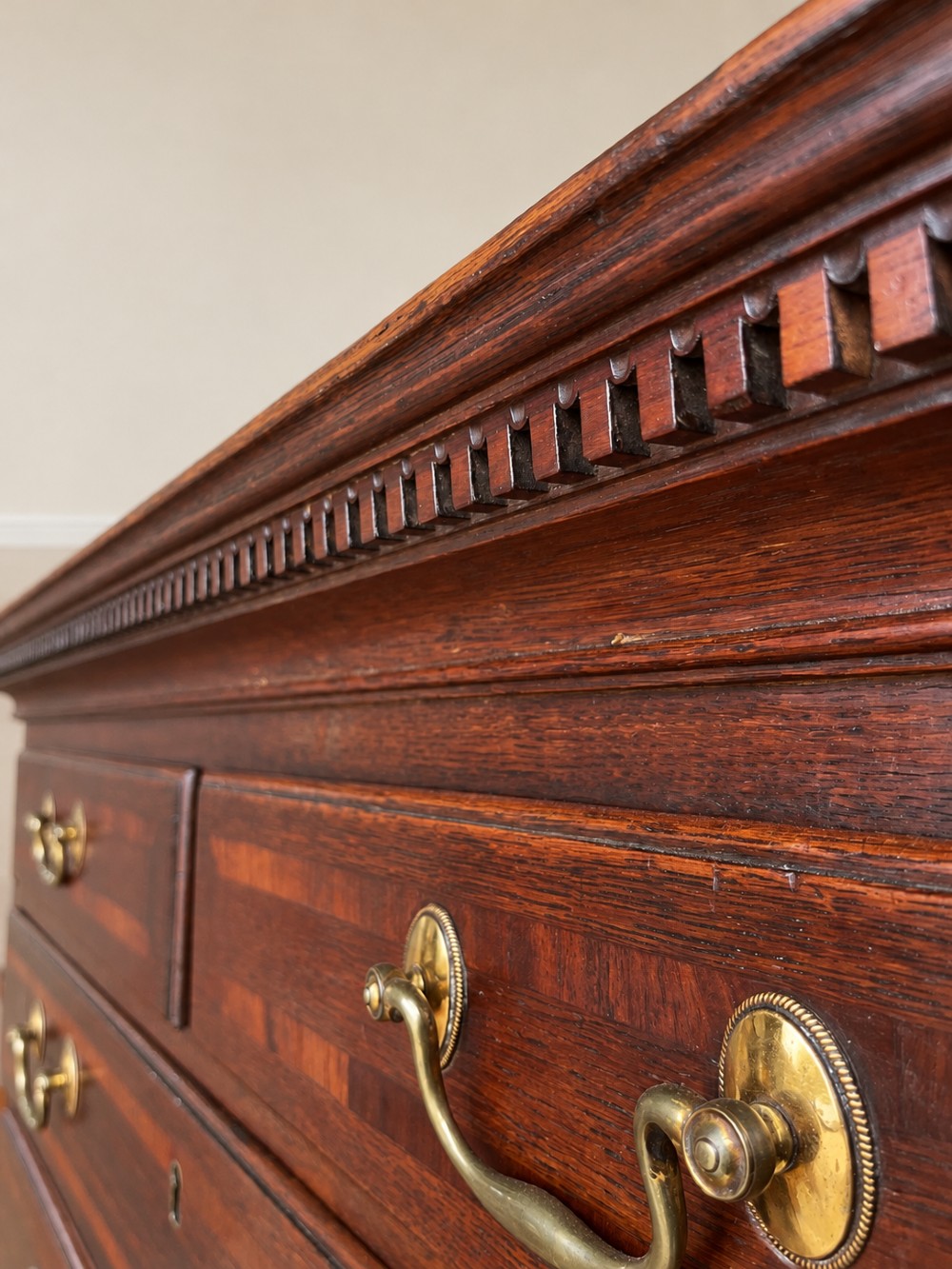 An antique Georgian oak chest on chest featuring two small top drawers over five full-width graduated drawers with brass swan-neck handles and bracket feet. View VII