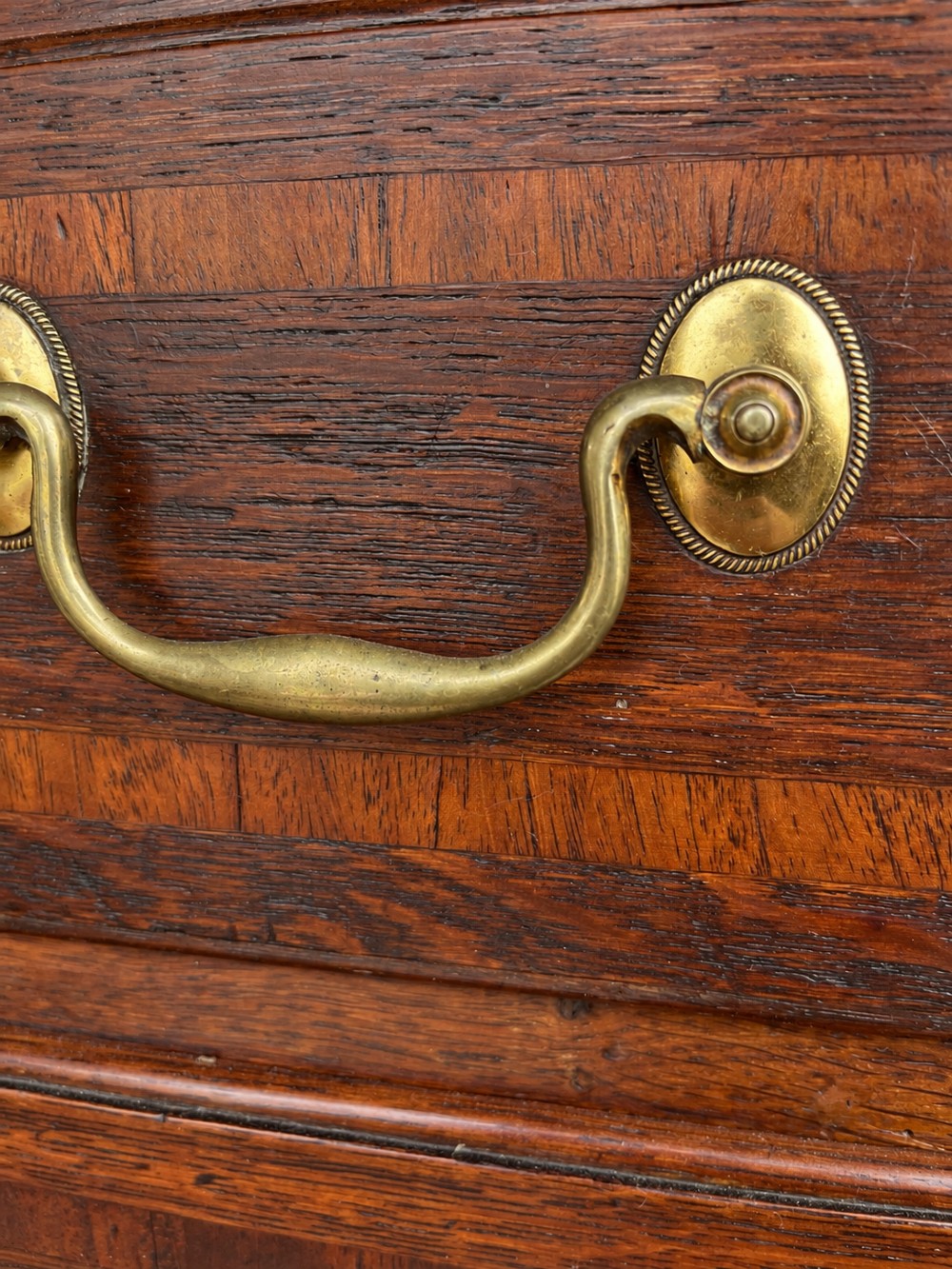 An antique Georgian oak chest on chest featuring two small top drawers over five full-width graduated drawers with brass swan-neck handles and bracket feet. View X