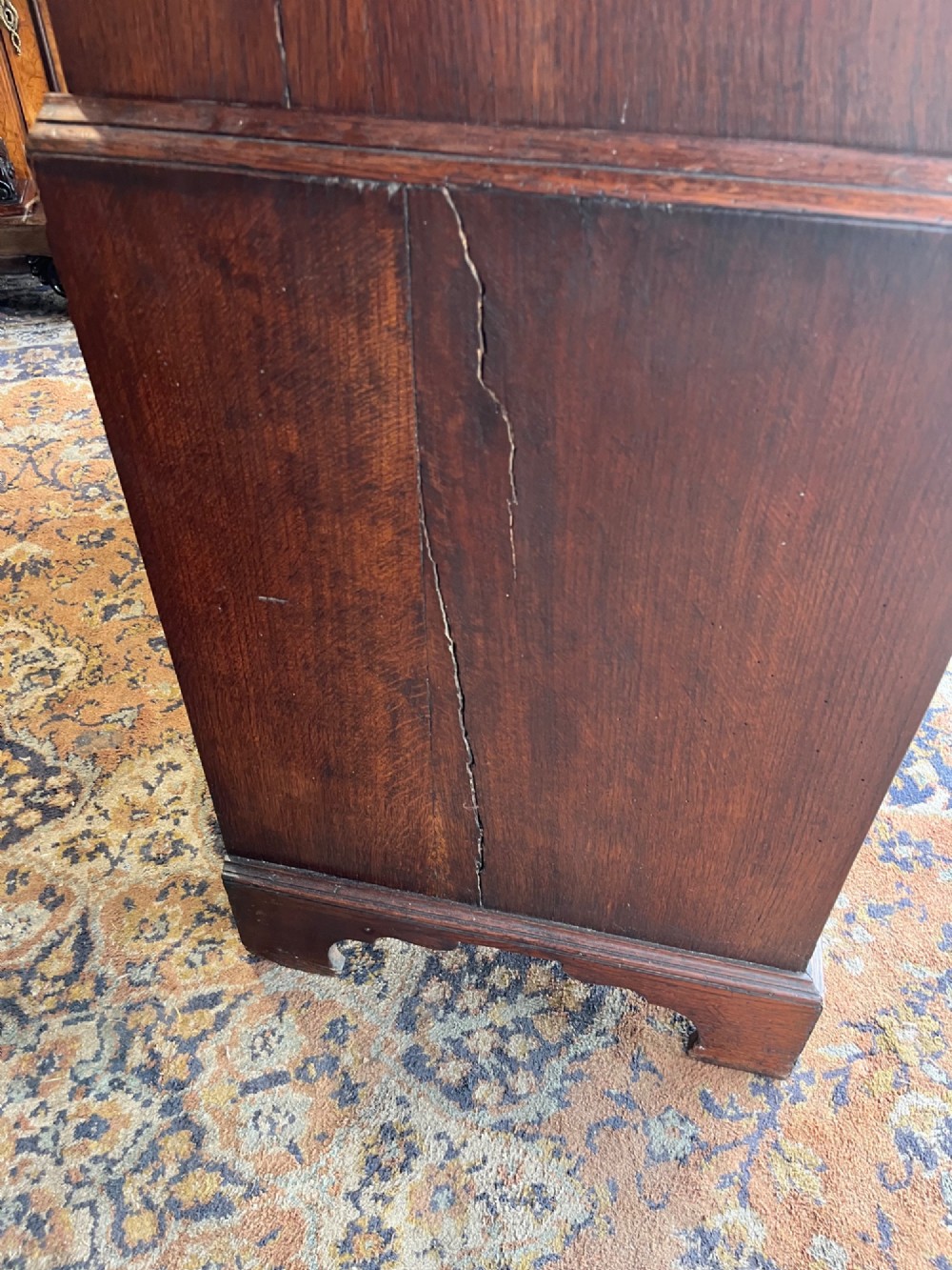 An antique Georgian oak chest on chest featuring two small top drawers over five full-width graduated drawers with brass swan-neck handles and bracket feet. View XIII