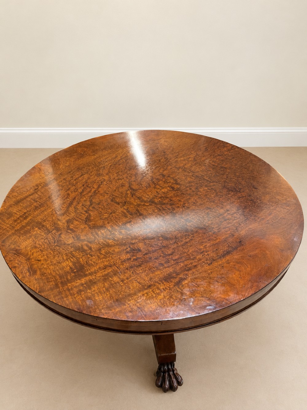 A 19th-century circular mahogany dining table featuring a polished top, turned central column with gadrooned base, and a tri-form platform resting on carved claw feet. View III