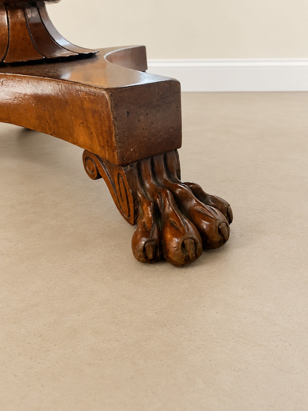 A 19th-century circular mahogany dining table featuring a polished top, turned central column with gadrooned base, and a tri-form platform resting on carved claw feet. View V