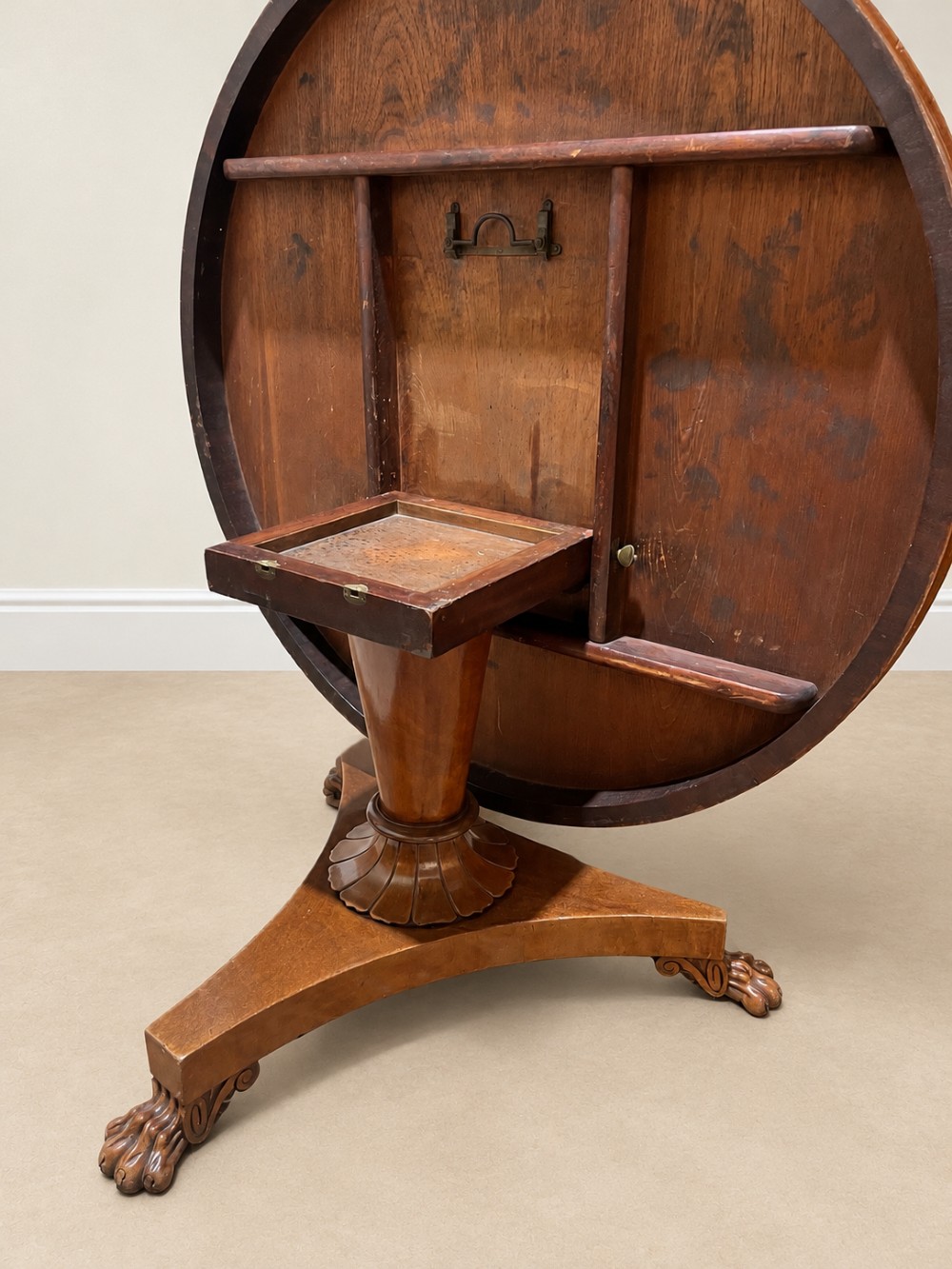 A 19th-century circular mahogany dining table featuring a polished top, turned central column with gadrooned base, and a tri-form platform resting on carved claw feet. View VII
