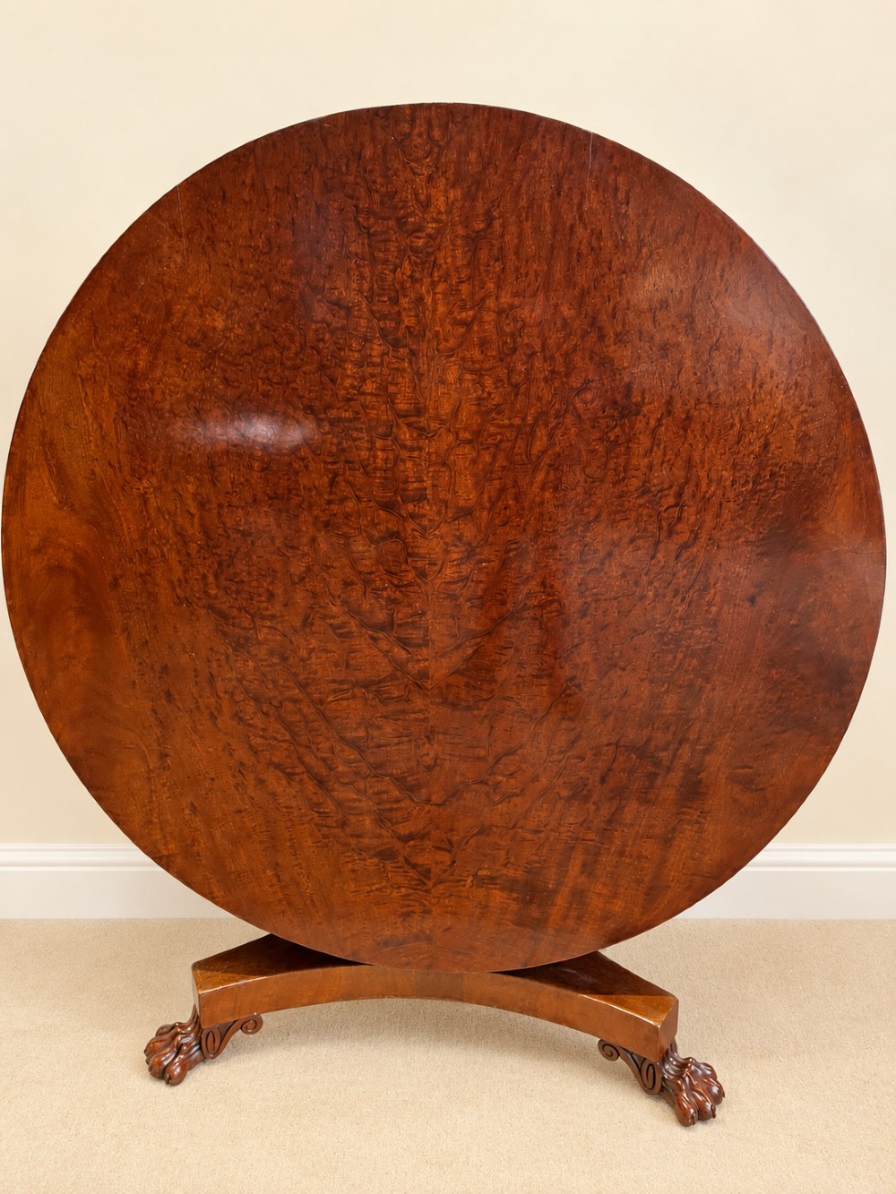 A 19th-century circular mahogany dining table featuring a polished top, turned central column with gadrooned base, and a tri-form platform resting on carved claw feet. View XI
