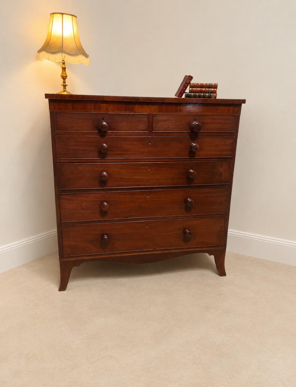 A 19th-century inlaid mahogany chest featuring two short drawers over three long drawers with turned knobs and splayed bracket feet.