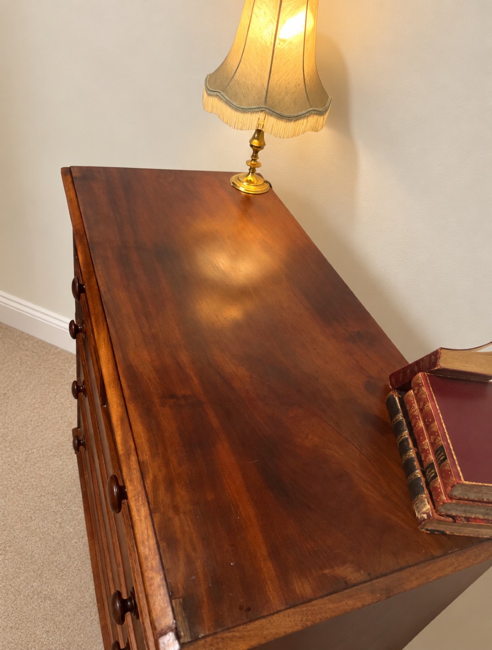 A nineteenth-century mahogany chest of drawers featuring two short over three long drawers with turned wooden knobs and turned feet. View IV