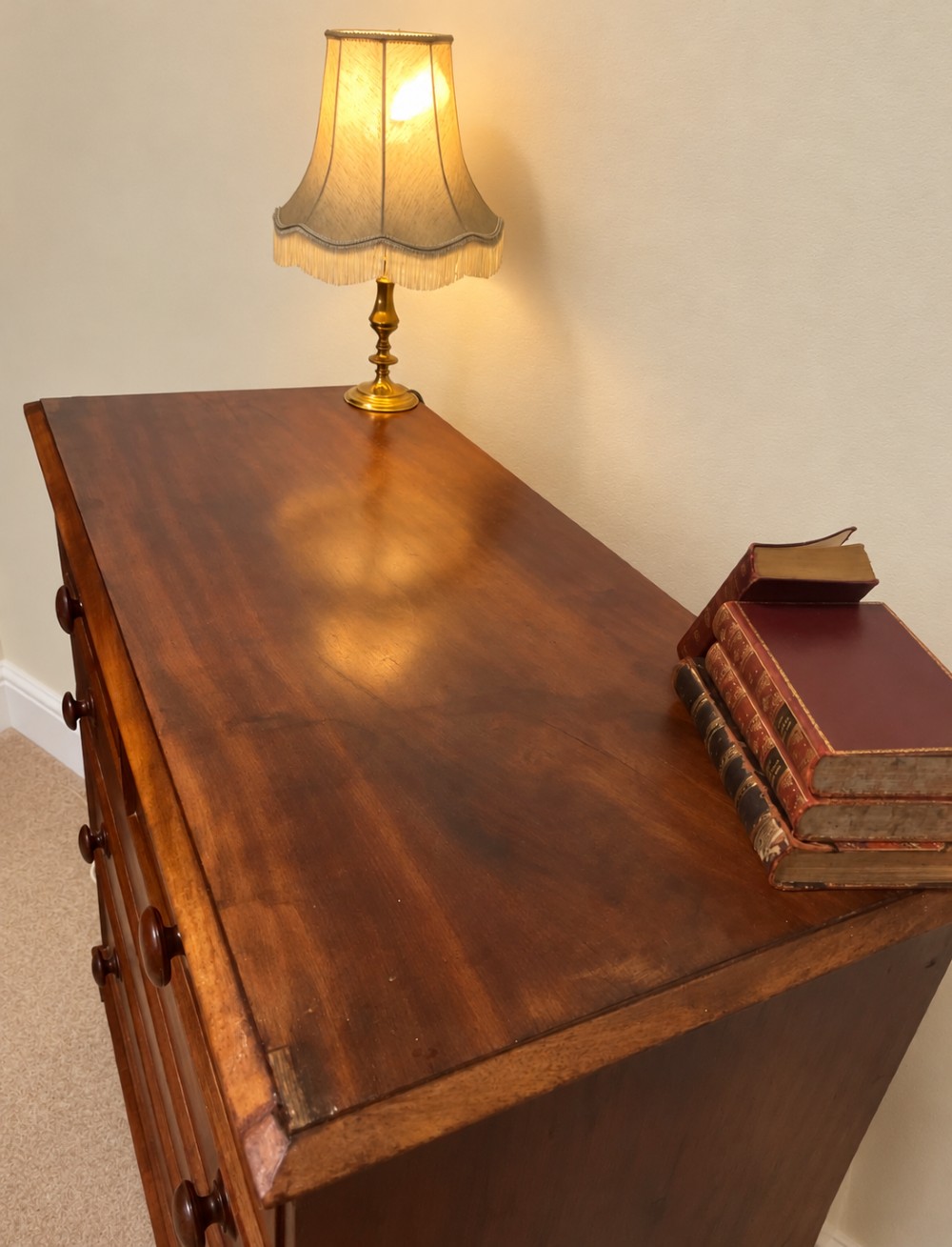 A nineteenth-century mahogany chest of drawers featuring two short over three long drawers with turned wooden knobs and turned feet. View V