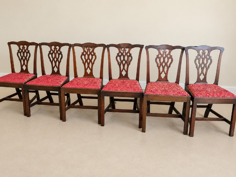 A set of six dark mahogany Georgian dining chairs featuring intricately pierced back splats and red patterned fabric drop-in seats. View VII