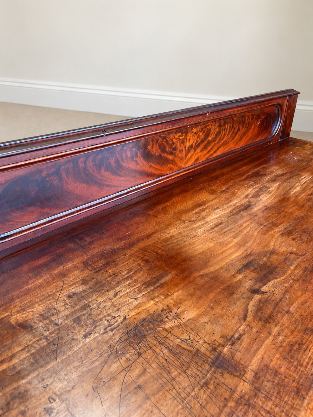 A 19th-century mahogany writing desk with a low gallery back, two frieze drawers, carved scroll trestle legs, and a turned stretcher. View IX