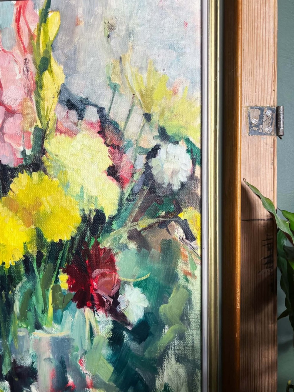 A framed mid-century oil on board painting featuring a colourful floral still life composition with yellow, pink, and green tones set within a wooden frame. View IX