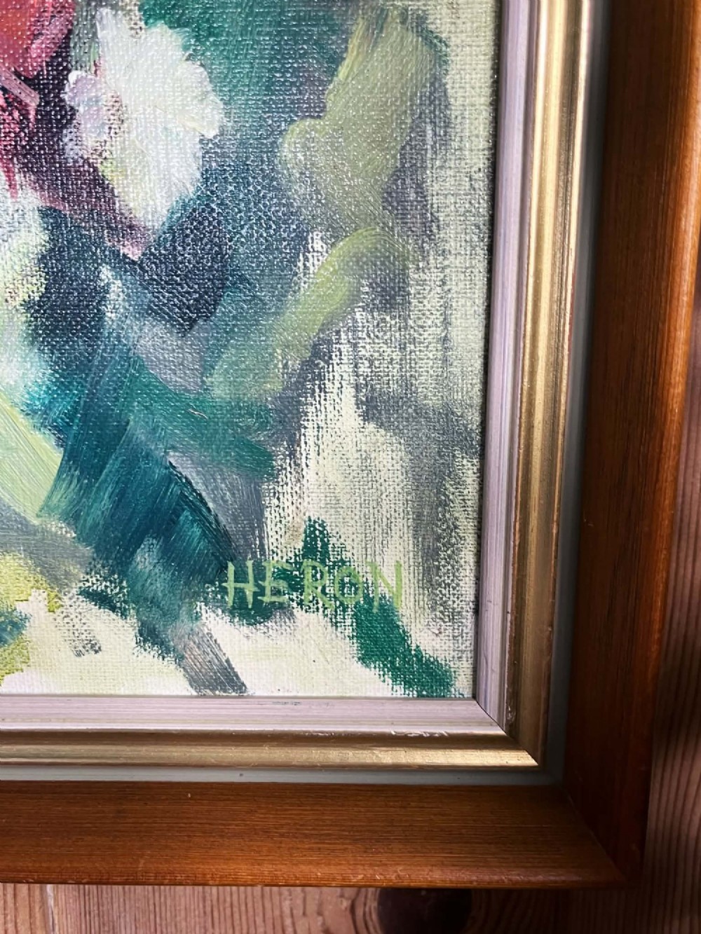 A framed mid-century oil on board painting featuring a colourful floral still life composition with yellow, pink, and green tones set within a wooden frame. View X