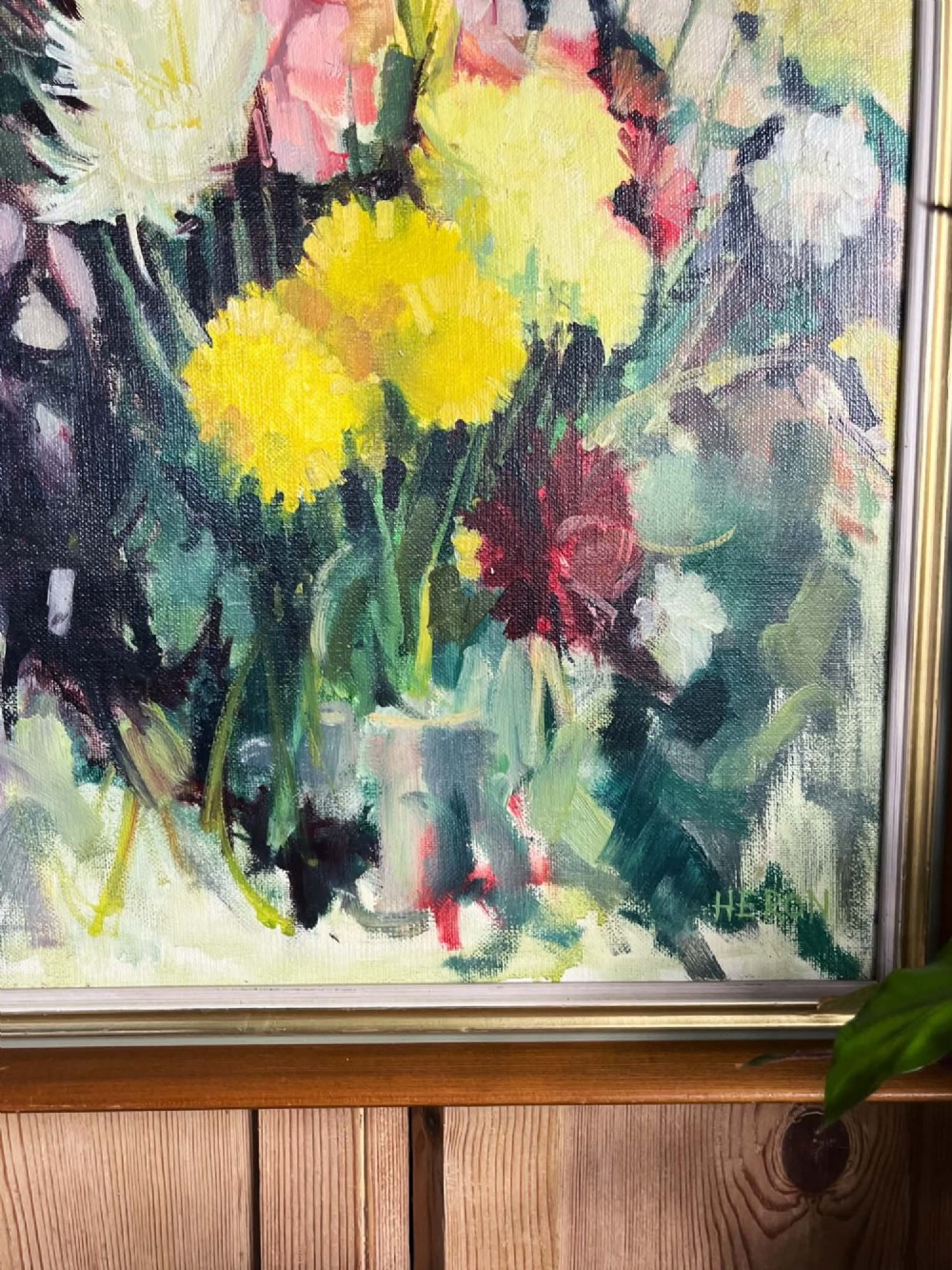 A framed mid-century oil on board painting featuring a colourful floral still life composition with yellow, pink, and green tones set within a wooden frame. View XII