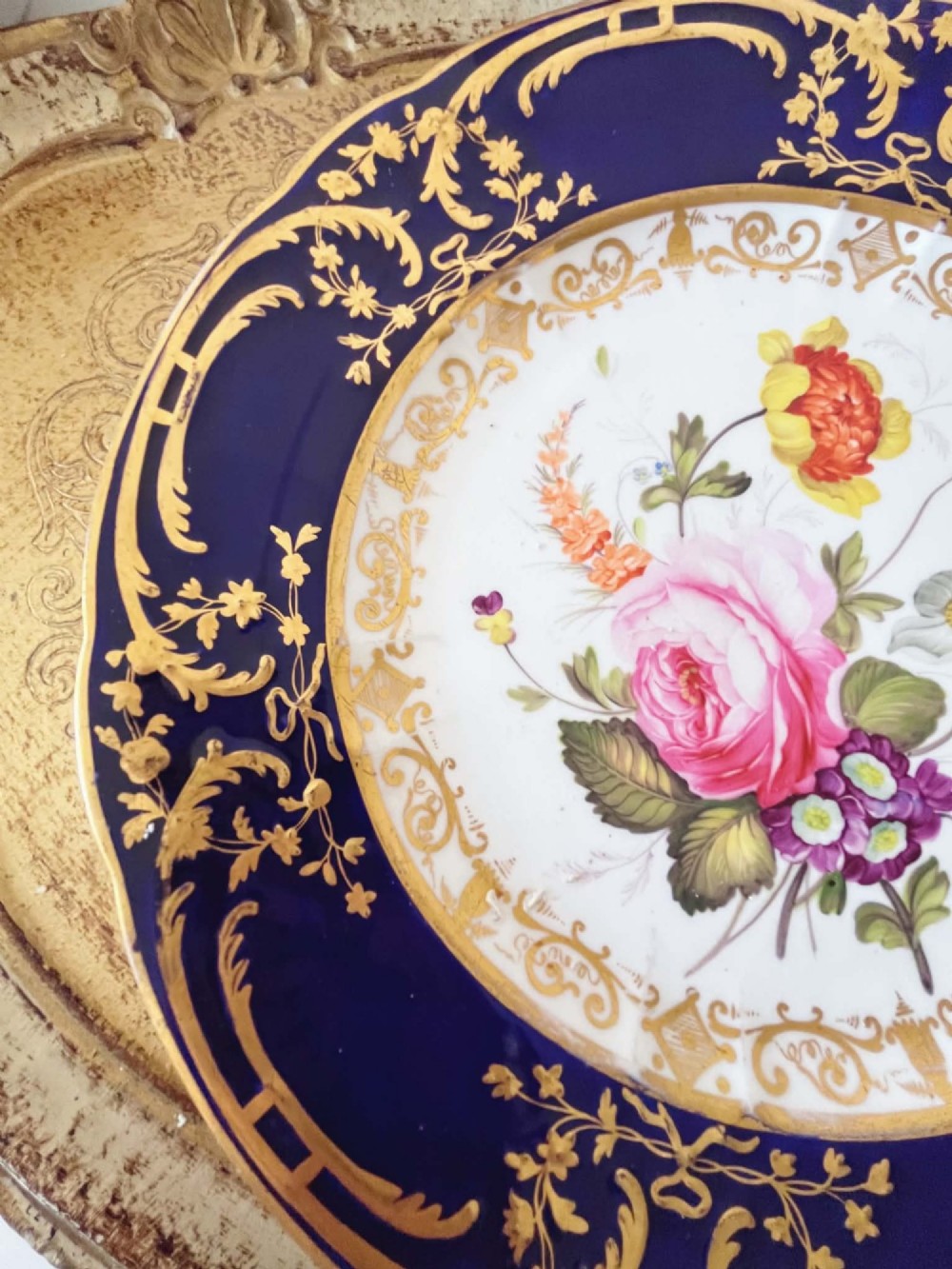 An antique Coalport porcelain dessert plate featuring a central hand-painted floral bouquet surrounded by a rich cobalt blue rim decorated with ornate gold gilding. View V
