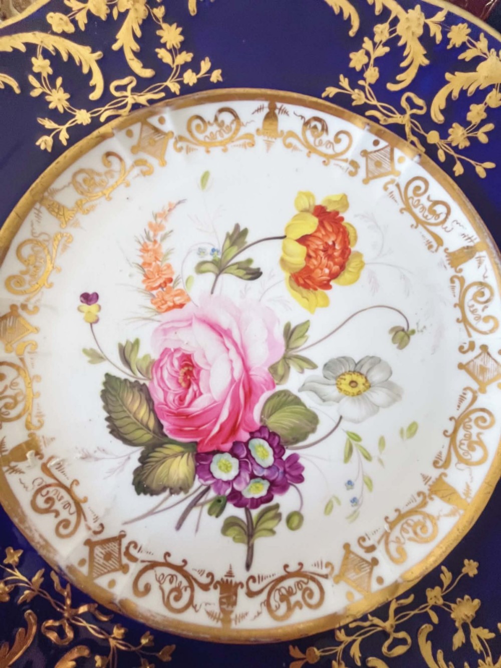 An antique Coalport porcelain dessert plate featuring a central hand-painted floral bouquet surrounded by a rich cobalt blue rim decorated with ornate gold gilding. View VIII