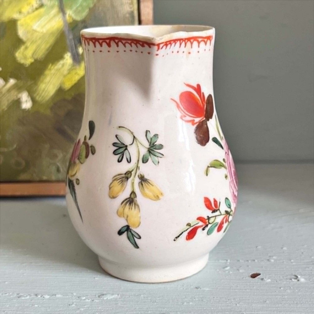 An eighteenth-century Bow soft-paste porcelain sparrowbeak cream jug hand-painted with polychrome floral sprigs and a red painted border. View VI